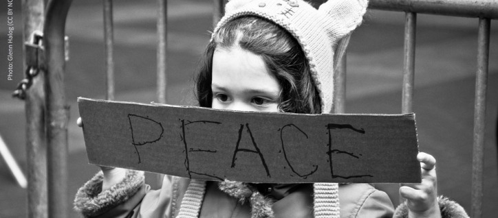 image of a girl holding a sign that says peace