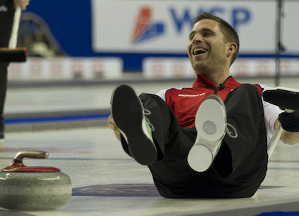 image of man sitting on ice in a curling rink