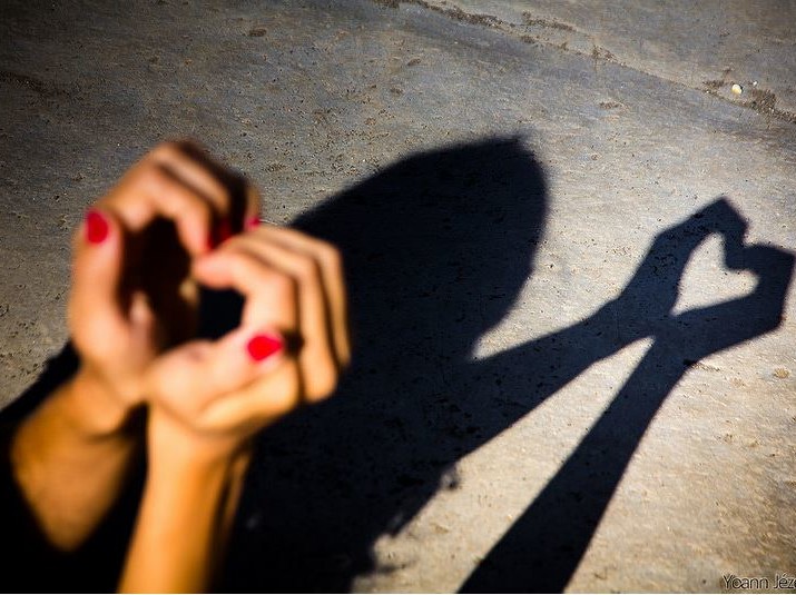 image of hands making a heart shaped shadow