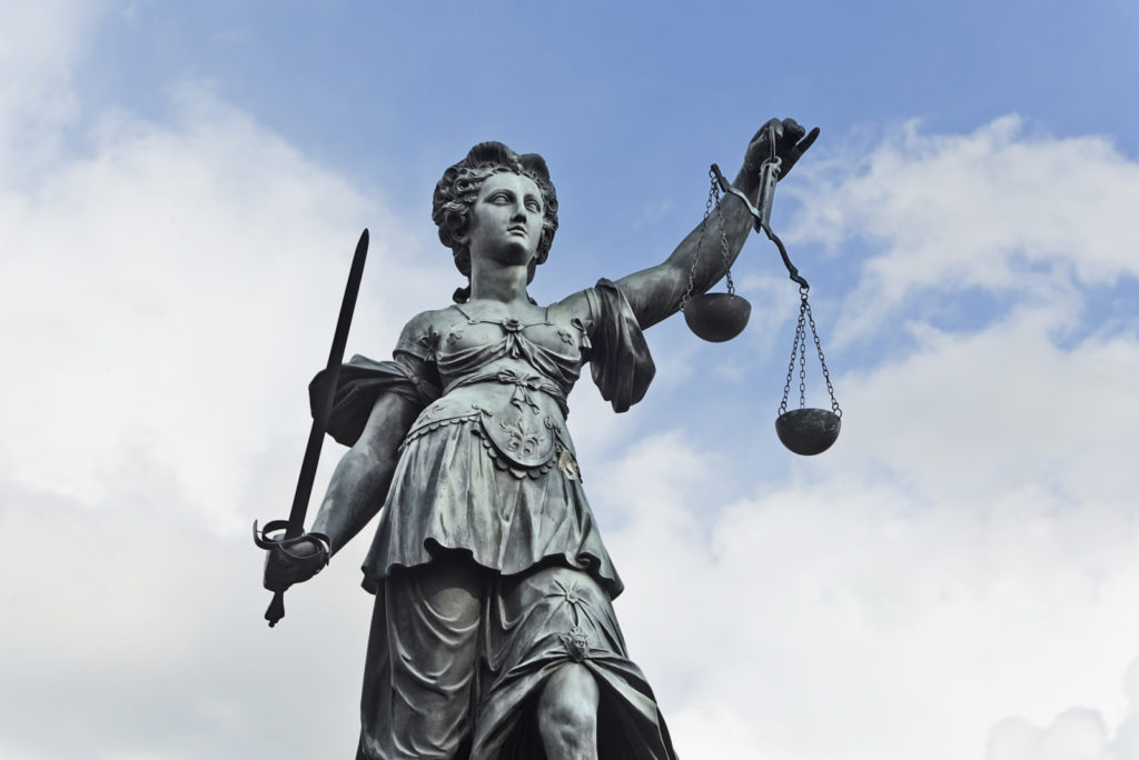 Image of a statue os justice with a sword and scales