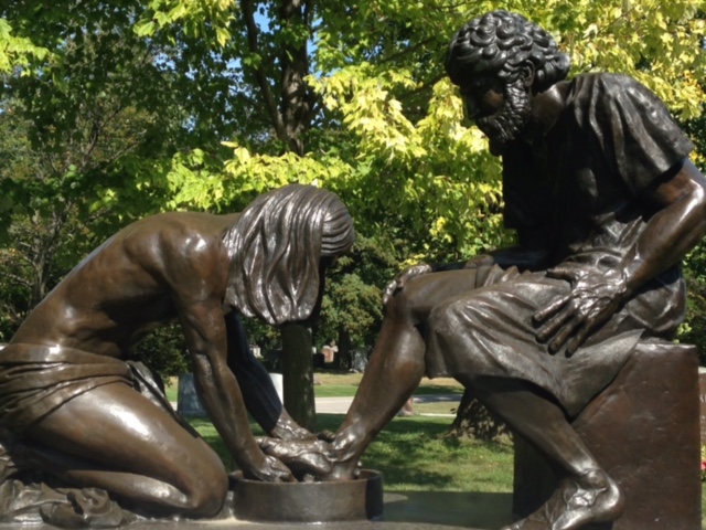 image of a statue of a woman washing a the foot of a man